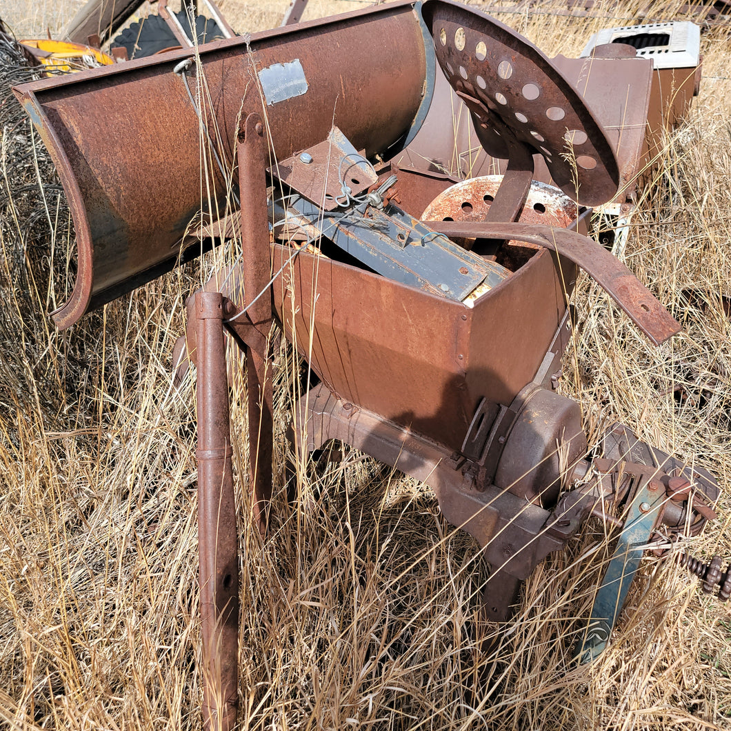 antique corn or grain grinder and tractor seat